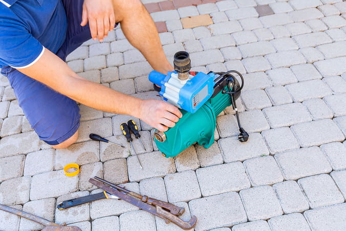 a plumber prepares a water pump for a private house